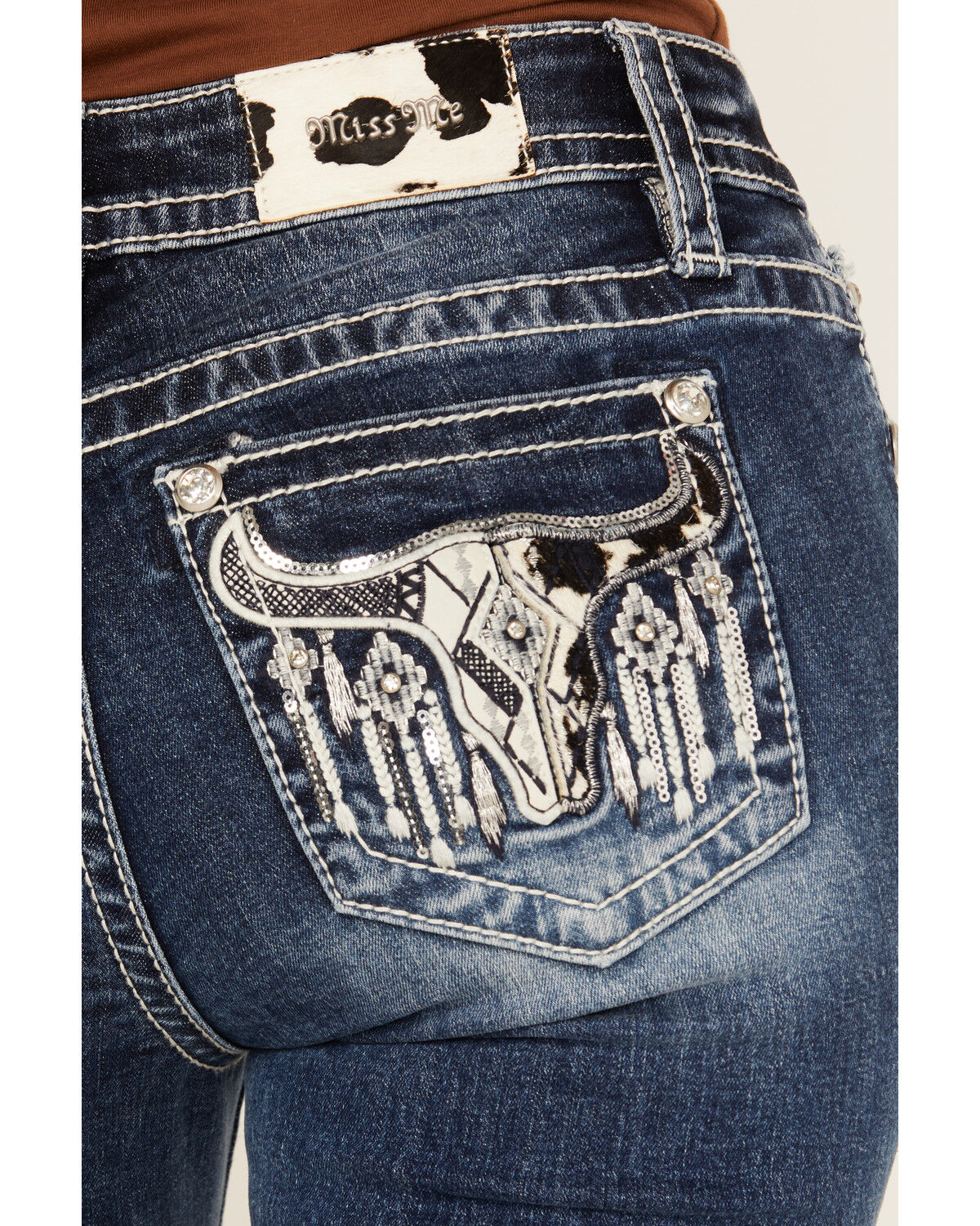 Product Name:  Miss Me Women's Medium Wash Mid Rise Cowhide Steer Head Pocket Bootcut Stretch Denim Jeans